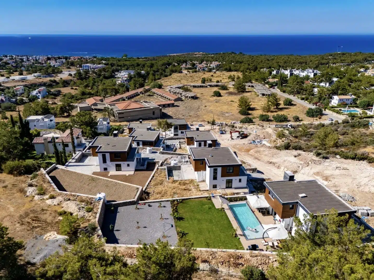 Luftaufnahme moderner Villen mit Privatpools, Gärten und Küste im Hintergrund in Çatalköy