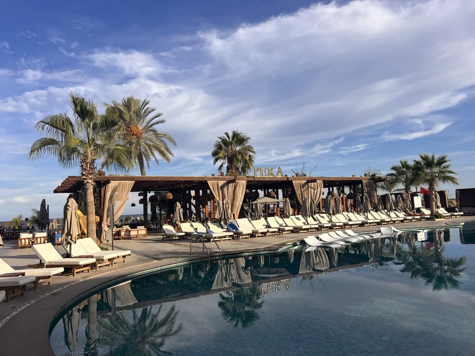Poollandschaft mit Palmen im Pera Beach Club am Long Beach in Nordzypern