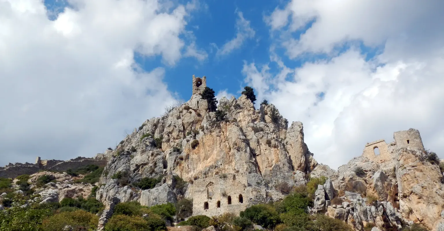 Ruinen der Burg St. Hilarion auf einem felsigen Bergkamm unter blauem Himmel